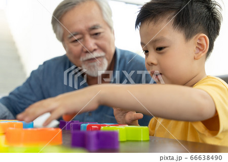 屋内でリラックスをするシニア男性と男の子 66638490