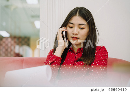 Beautiful asian woman in red shirt working at home 66640419