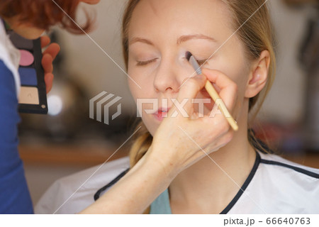 Woman getting make up done by artist 66640763