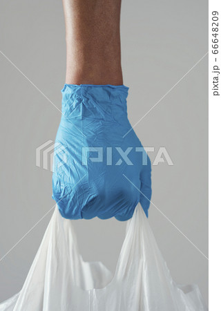 man wearing latex gloves carrying a shopping bag man wearing latex gloves carrying a shopping bag 66648209
