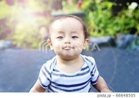 外で遊んで自慢げな表情をしている子供　水遊びしてずぶ濡れの子供 66648505