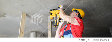 Builder works with special equipment on ceiling 66649893