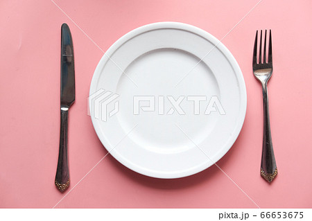 Clean plate and cutlery on pink background Clean plate and cutlery on pink background 66653675