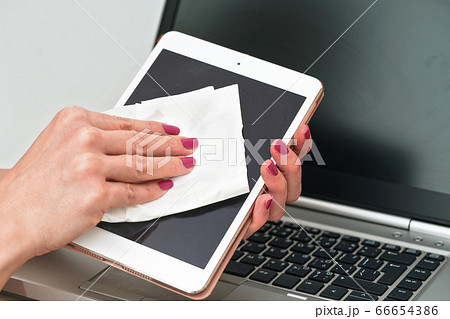 Woman cleaning tablet device with cotton paper 66654386