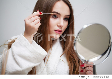 Beauty makeup, young woman with beautiful skin holding eyelash brush near eyes Beauty makeup, young woman with beautiful skin holding eyelash brush near eyes 66655148