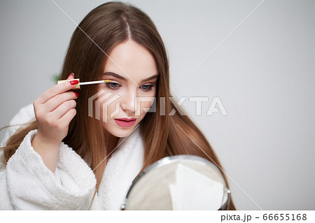 Beauty makeup, young woman with beautiful skin holding eyelash brush near eyes Beauty makeup, young woman with beautiful skin holding eyelash brush near eyes 66655168