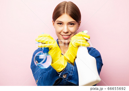 Woman cleaner in overalls and yellow gloves posing on a pink background 66655692