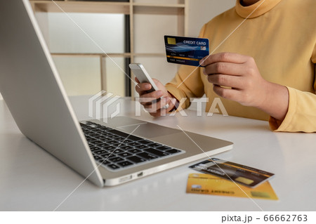 The hands of women holding credit cards and smartphones for online shopping and paying via the internet The hands of women holding credit cards and smartphones for online shopping and paying via the internet 66662763