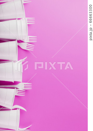 Disposable white plastic tableware on a pink Disposable white plastic tableware on a pink 66663300