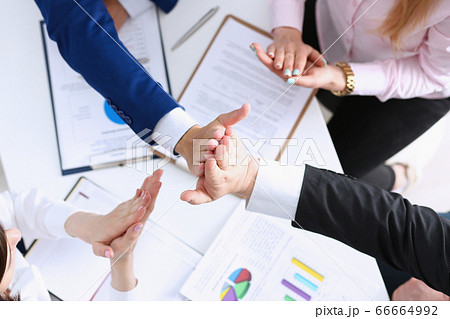 Group of people in suits crossed hands in pile Group of people in suits crossed hands in pile 66664992