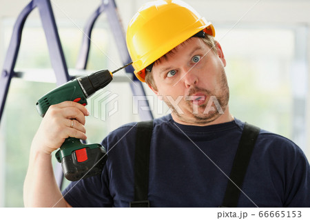 Idiot worker using electric drill portrait 66665153