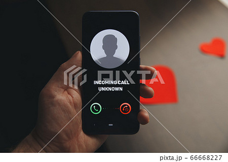Unknown number calling in the middle of the night. Phone call from stranger. Person holding mobile and smartphone home late. Unknown number calling in the middle of the night. Phone call from stranger. Person holding mobile and smartphone home late. 66668227
