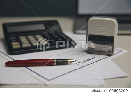 Close up woman hand using calculator and writing make note with calculate about cost at home office Close up woman hand using calculator and writing make note with calculate about cost at home office 66668269