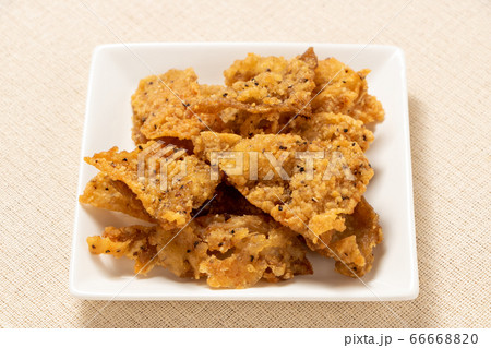 白い皿にのせられた鶏皮のスパイシー唐揚げ。 白い皿にのせられた鶏皮のスパイシー唐揚げ。 66668820