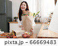 Cute asian woman holding shopping paper bag for breakfast in the kitchen,look at the camera and smile brightly. 66669483