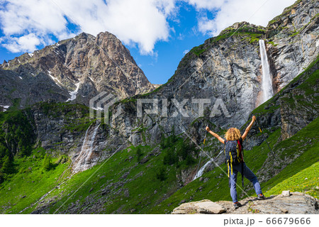 Lady hiker looking at waterfall on mountain. One 66679666