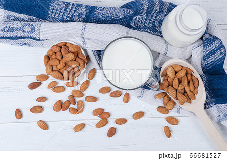 Almond milk in glass with spoon of almond nuts on 66681527