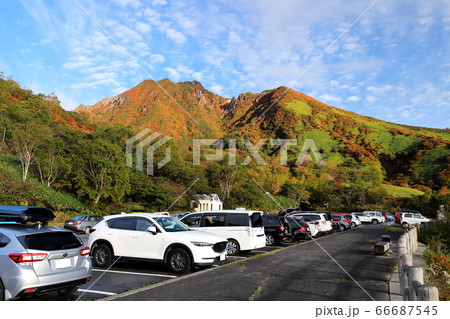 峠の茶屋駐車場より望む紅葉の那須朝日岳 日の出の写真素材
