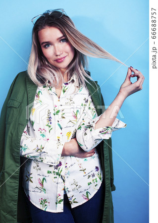 young pretty girl posing happy smiling on blue background, lifestyle people on summer vacation concept young pretty girl posing happy smiling on blue background, lifestyle people on summer vacation concept 66688757