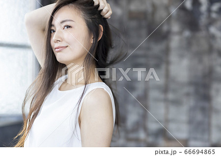 髪をかきあげる若い女性 ビューティーの写真素材