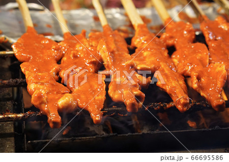 Roll of grilled chicken with coconut milk, Chicken in bamboo stick is charcoal grill, Thai food style from southern Roll of grilled chicken with coconut milk, Chicken in bamboo stick is charcoal grill, Thai food style from southern 66695586