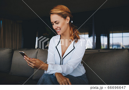 Attractive female watching video or reading business weblog in network on cell telephone Attractive female watching video or reading business weblog in network on cell telephone 66696647