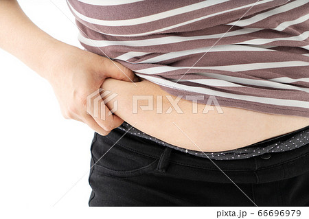 お腹の脂肪をつまむ中年女性の写真素材
