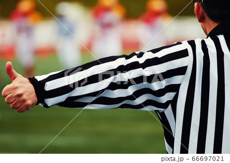 referee gestures with big team in of focus on background 66697021