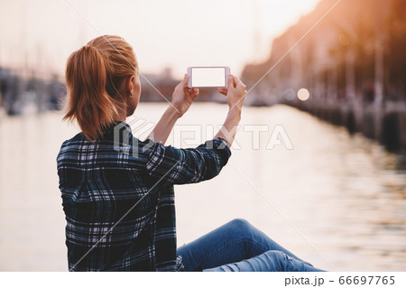 Woman tourist photographing beautiful sea landscape on cell telephone Woman tourist photographing beautiful sea landscape on cell telephone 66697765