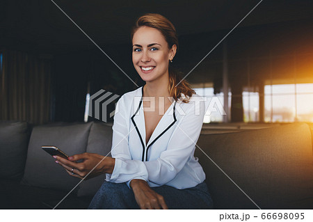 Attractive female watching video or reading business weblog in network on cell telephone Attractive female watching video or reading business weblog in network on cell telephone 66698095