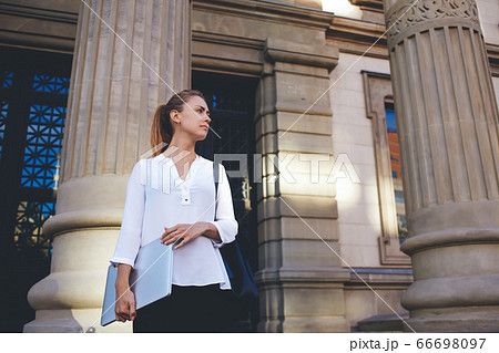 young woman office worker is having mobile phone conversation during work break young woman office worker is having mobile phone conversation during work break 66698097