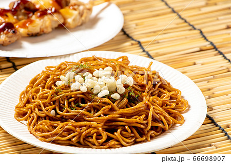 紙皿に盛られたソース焼きそば 写真奥には焼き鳥も 夏祭りの屋台メニューイメージ の写真素材