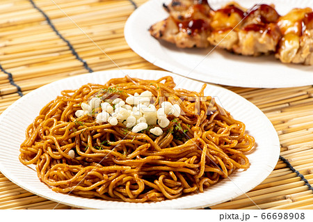 紙皿に盛られたソース焼きそば 写真奥には焼き鳥も 夏祭りの屋台メニューイメージ の写真素材