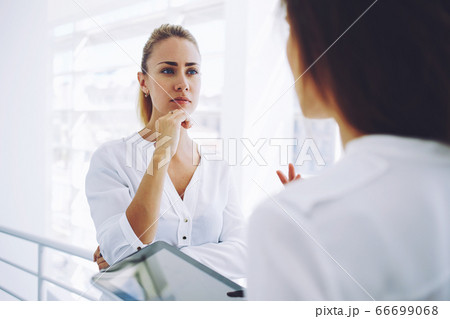 Two female employees having pleasant conversation after analyzing strategy on digital tablet 66699068