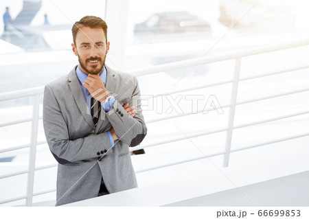 Male intelligent CEO is waiting business partners in hallway his company 66699853