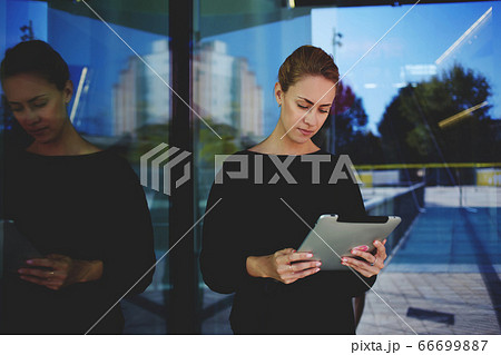 Portrait of beautiful young female holding mobile phone in hands  66699887