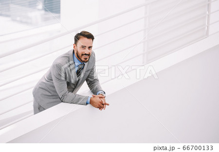 Male intelligent CEO is waiting business partners in hallway his company 66700133
