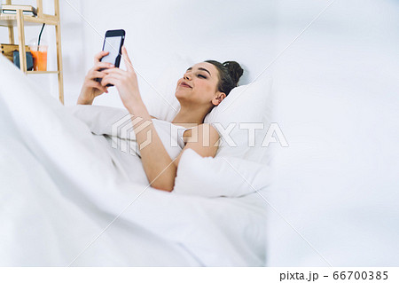 Delighted brunette chilling in bedroom and surfing mobile Delighted brunette chilling in bedroom and surfing mobile 66700385