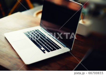 Workplace with open laptop with black screen on modern wooden desk 66700655