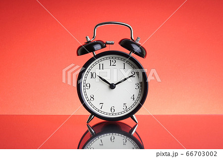 Alarm Clock on red background with selective focus Alarm Clock on red background with selective focus 66703002