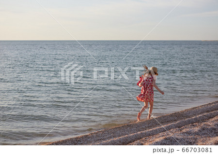Little girl running beach shore splashing water in blue sea 66703081