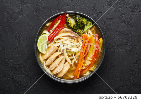 Chicken Thukpa in black bowl at dark slate background. Chicken Thukpa is Tibetan cuisine noodle soup 66703329