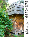 Corner of an old wooden house with lush greenery. 66704375