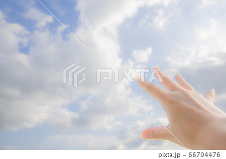 空に伸ばす手 雲を掴もうとする手の写真素材