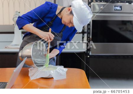 Woma pouring the finished cake into the mold. Woma pouring the finished cake into the mold. 66705453