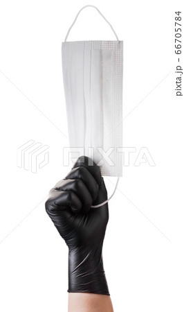 Hand in black gloves holding disposable face mask Hand in black gloves holding disposable face mask 66705784