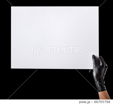 Hand in black gloves holding blank cardboard 66705798