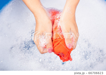 Woman use hands washing color clothes in basin Woman use hands washing color clothes in basin 66706623