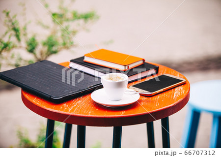 Workplace outdoors with different devices and cup of coffee 66707312