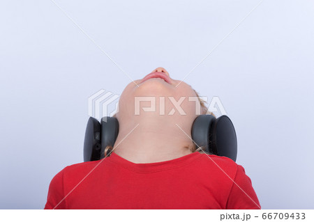 Boy in headphones looking at ceiling. Portrait of 66709433